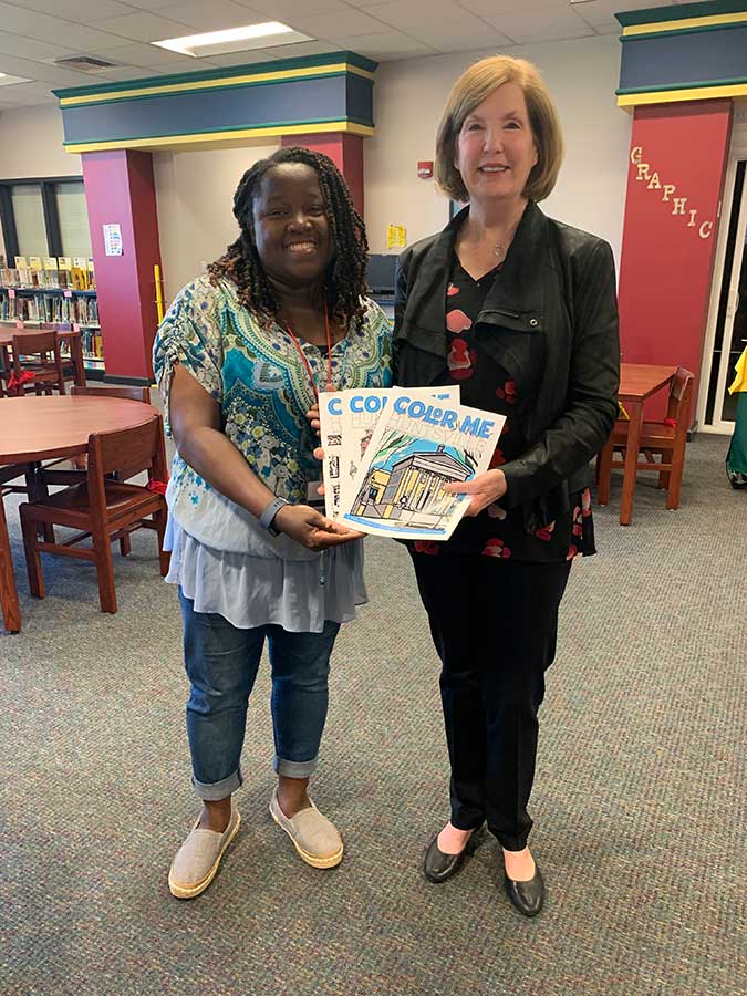 Donna presenta a set of Color Me, Huntsville coloring books to the Riverton Elementary School library.